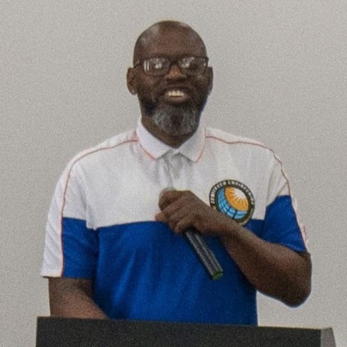 Picture of man standing behind podium with microphone in hand