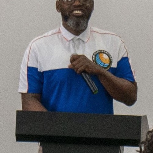 Picture of man standing behind podium with microphone in hand