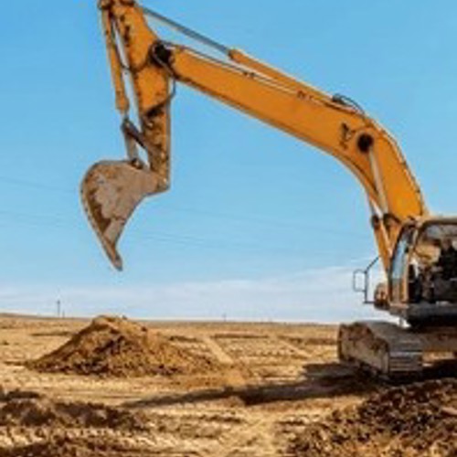 Yellow construction crane on dirt lot