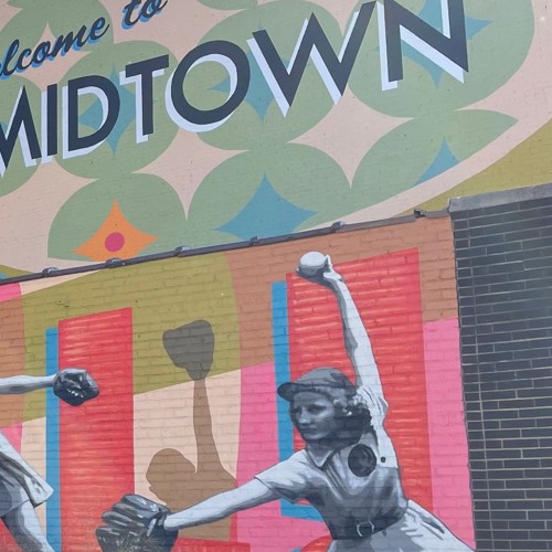 Outdoor murals reading Welcome to Midtown and including drawings of a woman baseball player