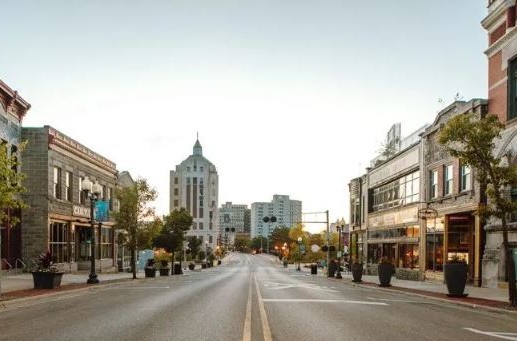 Looking down the double center line of a city street with buildings on both sides, disappearing into the horizon